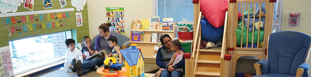 Early Childhood Room with students and teacher reading in a small group