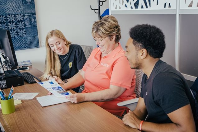 Two students work with a College advisor