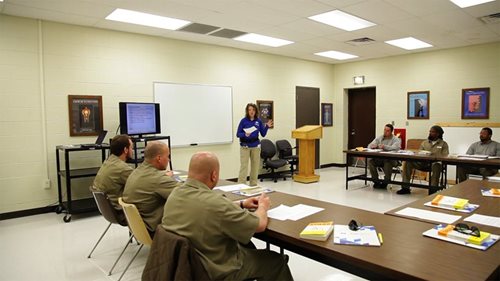 Incarcerated men listen attentively to their instructor