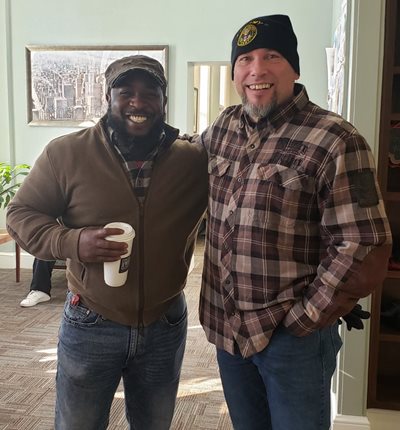 Two men pose for a photograph
