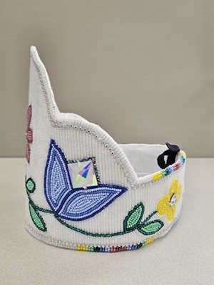 "The 2024 Princess crown is white with a pink flower in the center and purple tulips on either side"