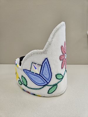 "The 2024 Princess crown is white with a pink flower in the center and purple tulips on either side"